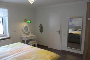 Schlafzimmer mit einem Bett, einem Waschbecken und einem Spiegel in der Unterkunft Ferienwohnung Kordes in Winterberg