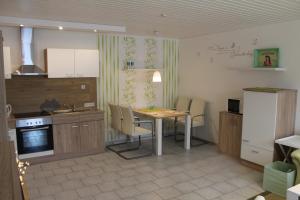eine Küche mit einem Tisch und Stühlen sowie einem Kühlschrank in der Unterkunft Ferienwohnung Kordes in Winterberg