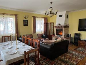a living room with a table and a fireplace at Horace Guesthouse POOL & HOT TUB & BIKES & RIVER in Dejani