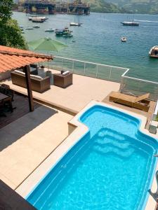 a swimming pool with a view of the water at Casa Martureza in Angra dos Reis