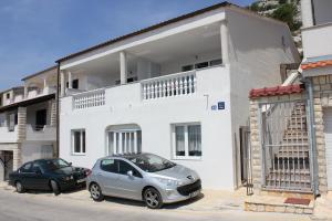 ein silbernes Auto, das vor einem weißen Gebäude parkt in der Unterkunft Apartments Toni Na Moru in Drage