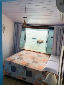 Schlafzimmer mit einem großen Fenster mit einem Bett in der Unterkunft Casa Martureza in Angra dos Reis