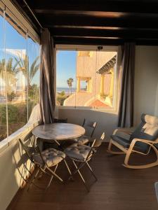 Appartement Casablanca Garden Beach في الدار البيضاء: طاولة وكراسي في غرفة مع نافذة