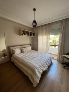 Appartement Casablanca Garden Beach في الدار البيضاء: غرفة نوم بسرير كبير ونافذة
