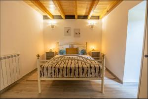 una camera con un letto in una stanza con soffitto in legno di Casa da Avó Ana a Prado Gatão