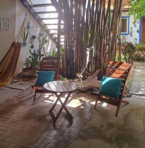 eine Terrasse mit 2 Stühlen, einem Tisch und einer Hängematte in der Unterkunft Hostal Jardin in Mahahual