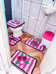 a bathroom with a toilet and mats on the floor at Casa da Debora in Lençóis +61 photos