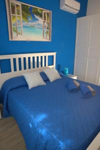Un dormitorio azul con una gran cama azul con almohadas en sea ottiolu, en Porto Ottiolu