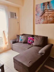 a brown couch in a living room with a painting at The Rochester Parklane Condominium in Manila