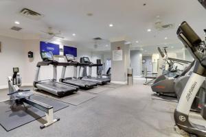 a gym with treadmills and elliptical machines at Stylish Condo Near Ballston Metro in Arlington