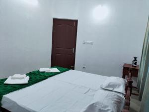 Un dormitorio con una cama con dos toallas encima. en Palmy Residency, en Alleppey