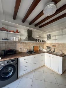 a kitchen with white cabinets and a washing machine at Appartement Casablanca Garden Beach in Casablanca