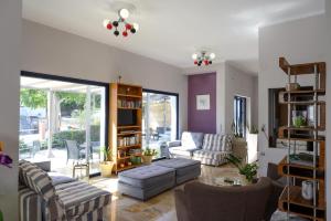 a living room with a couch and chairs at Ilioxenia Chios Studios & Apartments in Paralia Agias Foteinis