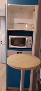 a small kitchen with a table and a microwave at hotelF1 Compiègne in Venette