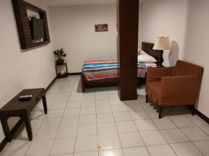 LEHNS MOTEL في كورور: غرفة معيشة مع كرسي وسرير