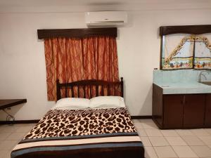 a bed in a room with a window and a sink at LEHNS MOTEL in Koror