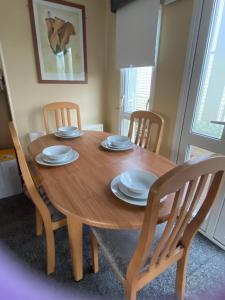 a wooden dining room table with four chairs and a wooden table and chairsktop at Croft View in Taynuilt