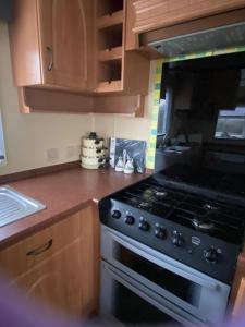 a kitchen with a stove and a microwave at Croft View in Taynuilt
