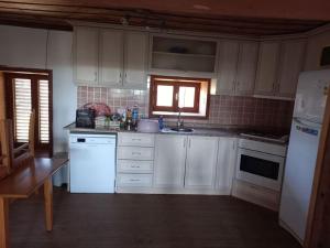una cocina con armarios blancos y electrodomésticos blancos en 4 yatak odalı Harika müstakil villa en Manavgat