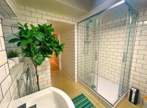 a bathroom with a shower and a toilet and a plant at Bristol City Stays - Harbourside Apartments in Bristol