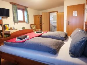 - une chambre avec 2 lits et une couverture rouge dans l'établissement Landhotel Oberwengerhof, à Spital am Pyhrn