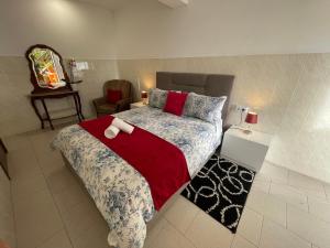 1 dormitorio con 1 cama grande con manta roja en Sunset House en Arco da Calheta