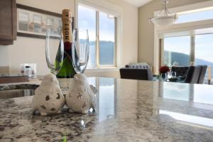 two white birds sitting on a table with a bottle of wine at 3 bed, 2 bath upper suite overlooking the city in Vernon