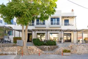 un bâtiment avec un arbre en face dans l'établissement Ilioxenia Chios Studios & Apartments, à Paralia Agias Foteinis