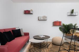 a living room with a red couch and a table at Blue Lagoon by HolyGuest in Tel Aviv