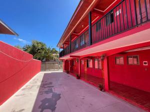um edifício vermelho com uma parede vermelha e um passeio em Hospedaje Los Abuelos em Pichilemu