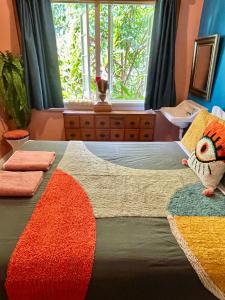 1 dormitorio con 1 cama con una manta colorida y una ventana en Babinda Quarters, en Babinda
