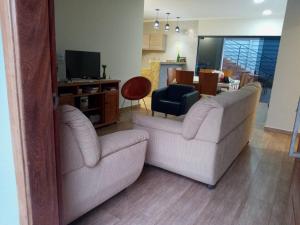 un salon avec deux canapés et une télévision dans l'établissement Pirassununga, SP - Casa 3 suítes em condomínio RURAL - 06 hóspedes Confortáveis, à Pirassununga