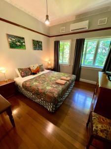 a bedroom with a bed and two windows at Babinda Quarters in Babinda