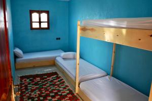 a room with two bunk beds and a window at Be Free Surfhouse in Tamri
