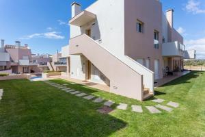 uma casa branca com uma escada num quintal em Burgau 2floor appt in condominium w/ shared pool no Burgau