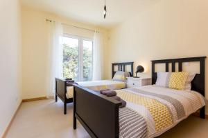 um quarto com duas camas e uma janela em Burgau 2floor appt in condominium w/ shared pool no Burgau mais 29 fotografias