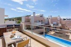 uma varanda com uma mesa e vista para um edifício em Burgau 2floor appt in condominium w/ shared pool no Burgau