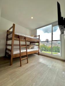 1 dormitorio con literas y ventana grande en Exclusivo Apartamento De Lujo cerca a cable plaza, en Manizales