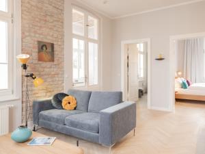 a living room with a couch and a brick wall at OSTKÜSTE - Villa Groth Design Apartments in Heringsdorf