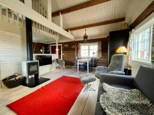 a living room with a couch and a red rug at Backgårdens Timmerstuga in Falköping