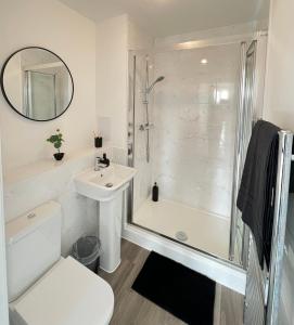 La salle de bains blanche est pourvue d'une douche et d'un lavabo. dans l'établissement Riverside Apartment Chelmsford, à Chelmsford