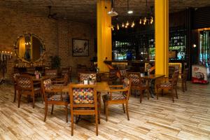 a restaurant with wooden tables and chairs in a room at Hotel El Meson in La Dorada