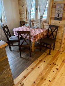 een eetkamer met een tafel en 2 stoelen bij Apartments Milev in Mokra Gora