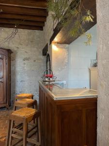 a kitchen with a counter and stools in a room at Le Relais, La Dormance, Le Bois Dormant in Châteauvieux
