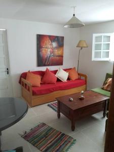 a living room with a red couch and a coffee table at Casa Lola in Barra de Valizas