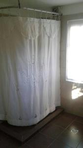 a white shower curtain in a bathroom with a window at Casa Lola in Barra de Valizas