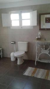 a bathroom with a toilet and a sink at Casa Lola in Barra de Valizas