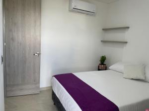 1 dormitorio con 1 cama grande y puerta en DIMALU LOFT en Roldanillo