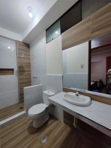 y baño con aseo blanco y lavamanos. en Hostal Bryan, en Tacna