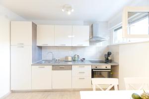 - une cuisine avec des placards blancs et un évier dans l'établissement City Break apartment, à Split